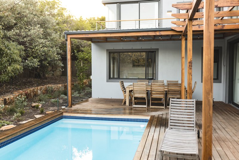 Patio trasero con terraza y deck de madera con alberca en Puebla